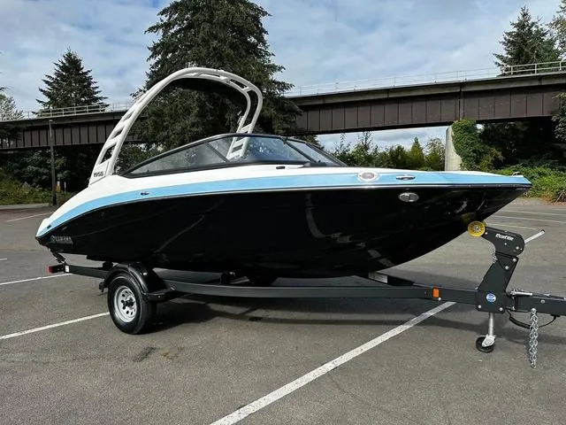 Slide: The Image of 2025 Yamaha Boats 195S on trailer, sleek black and blue design, parked outdoors. - 3