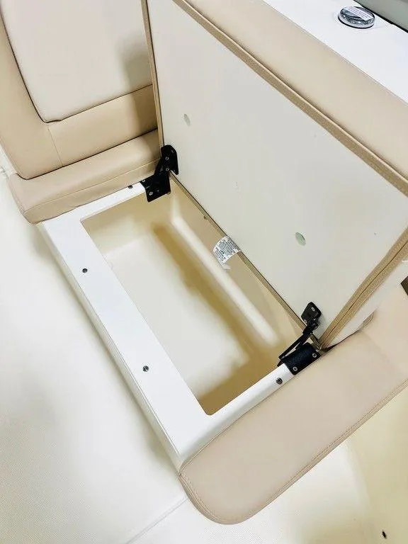 Slide: The Image of Open storage compartment in 2025 Scout 195 Sport Dorado boat, featuring beige interior. - 7