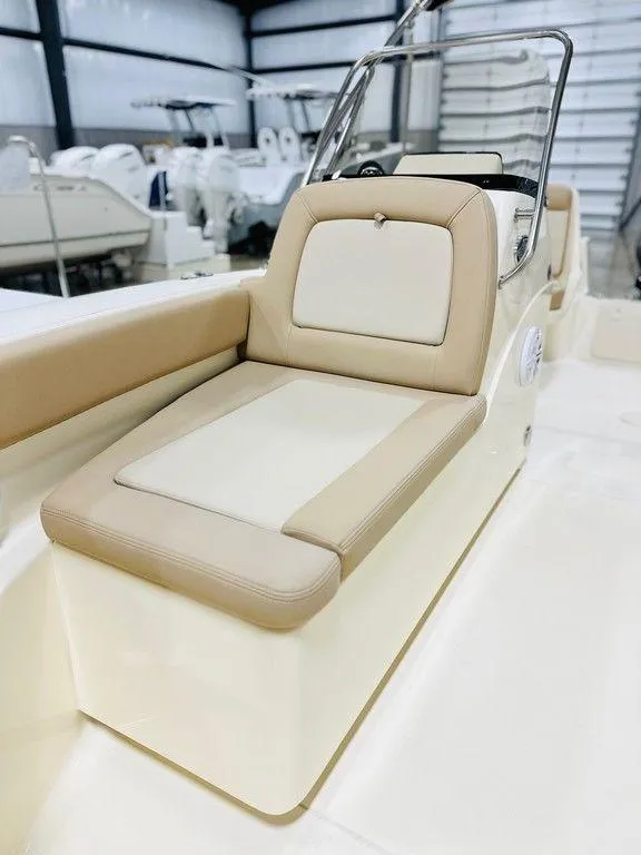 Slide: The Image of 2025 Scout 195 Sport Dorado boat interior with beige seating in a showroom. - 8