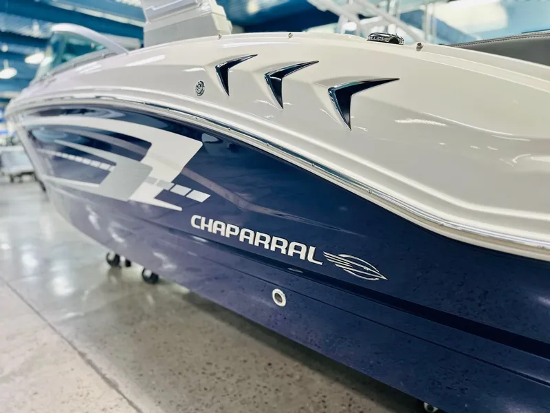 Slide: The Image of 2025 Chaparral 21 SSi OB boat, sleek blue and white design, showroom display. - 14