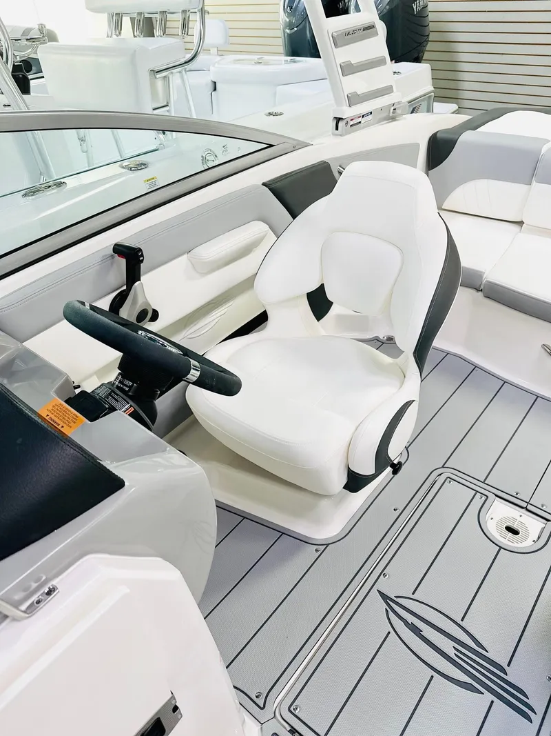 Slide: The Image of 2025 Chaparral 21 SSi OB boat interior with white seating and modern steering console. - 4