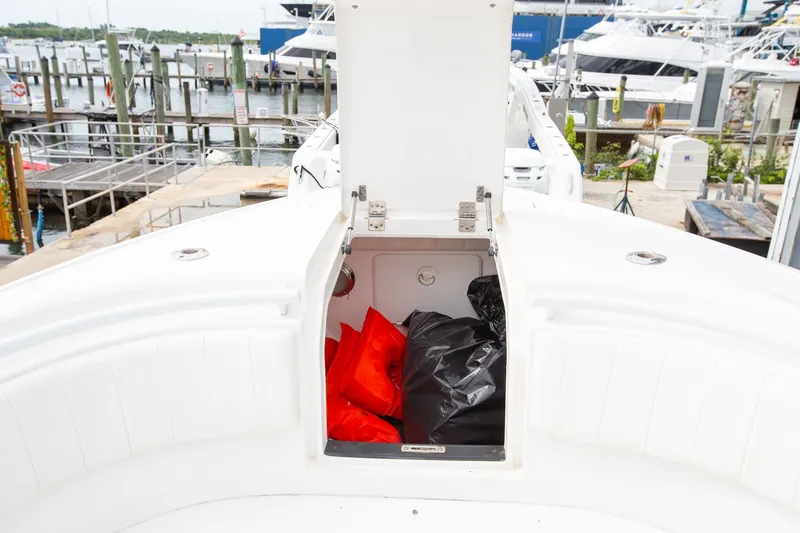 Slide: The Image of Open storage compartment on 2011 Intrepid 32 boat with life jackets inside. - 14