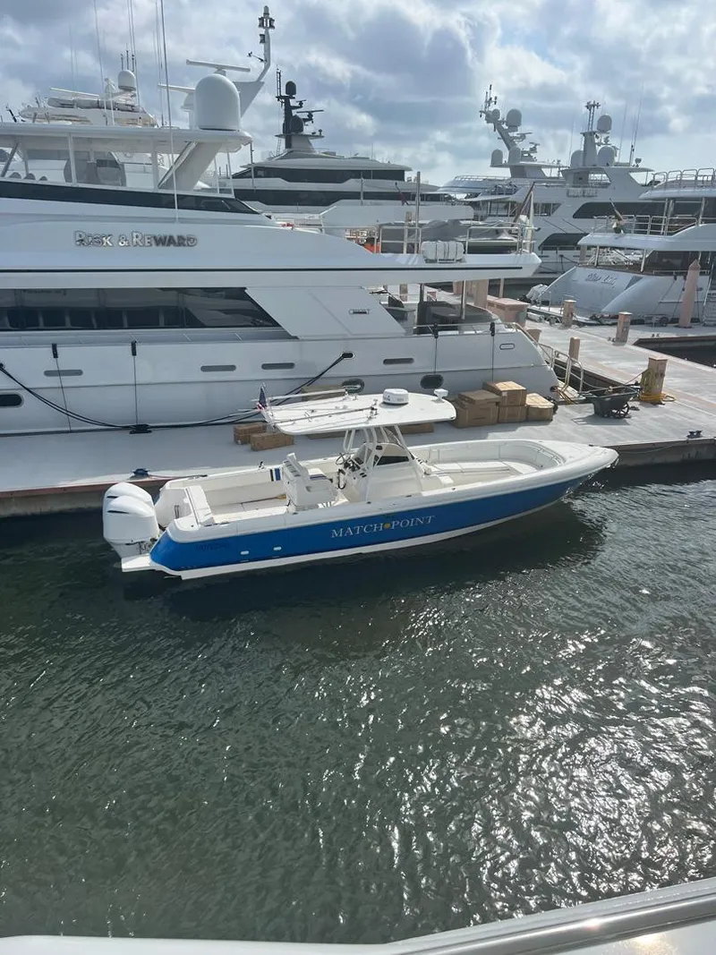 Slide: The Image of 2011 Intrepid 32 boat docked at marina, surrounded by luxury yachts. - 25