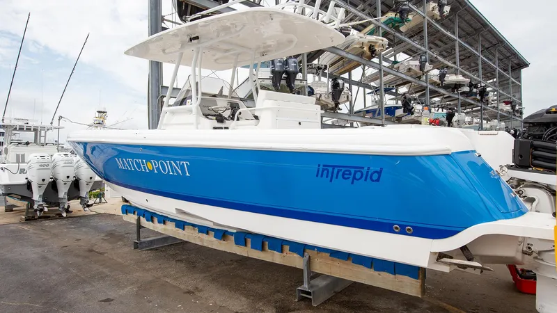 Slide: The Image of 2011 Intrepid 32 boat in dry dock, blue and white hull, side view. - 5