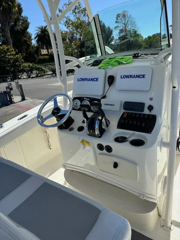 Slide: The Image of 2018 Mako 234 Center Console boat dashboard with Lowrance electronics and steering wheel. - 12