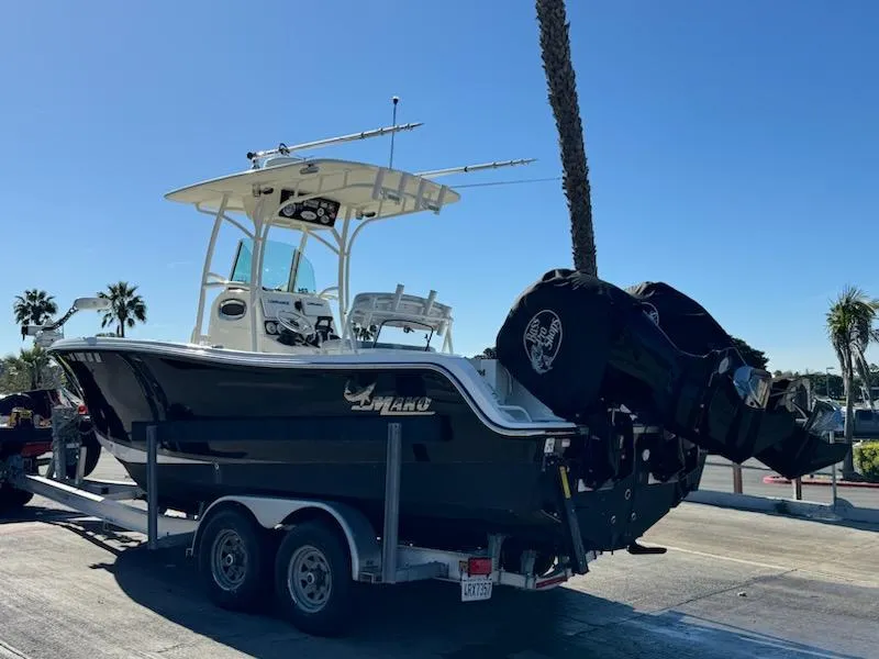 Slide: The Image of 2018 Mako 234 Center Console boat on trailer under clear blue sky. - 13