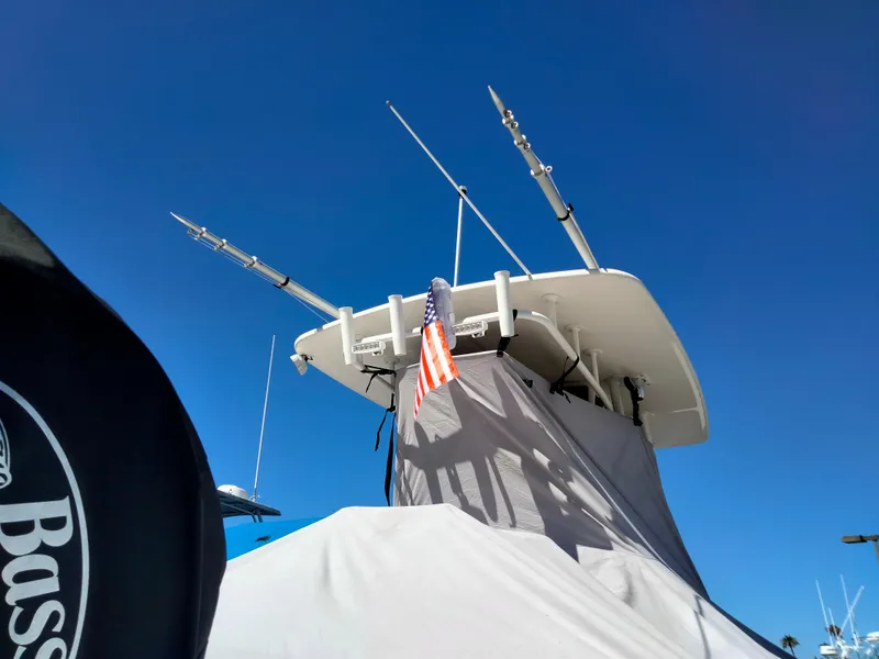 Slide: The Image of 2018 Mako 234 Center Console boat with fishing rods and American flag against blue sky. - 7