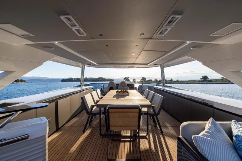 Slide: The Image of Luxurious 2024 Absolute NAVETTA 75 yacht deck with elegant dining area and scenic ocean view. - 31