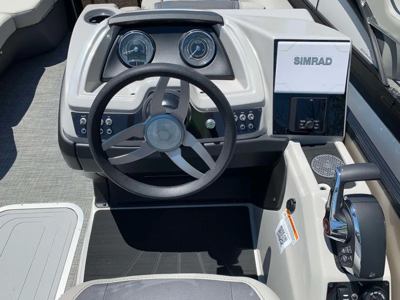 Slide: The Image of 2025 Barletta Cabrio 22UC boat dashboard with steering wheel and Simrad display. - 10