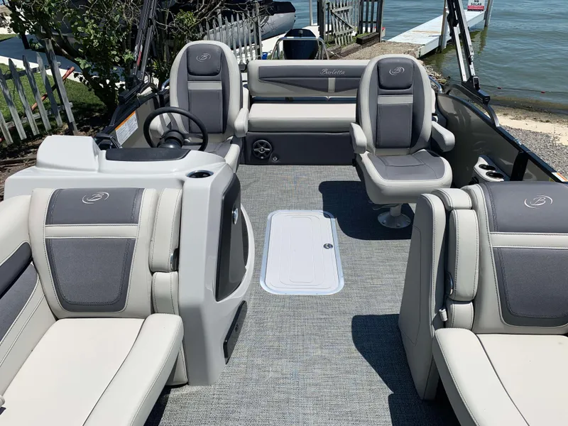 Slide: The Image of 2025 Barletta Cabrio 22UC pontoon boat interior with plush seating and steering console. - 6