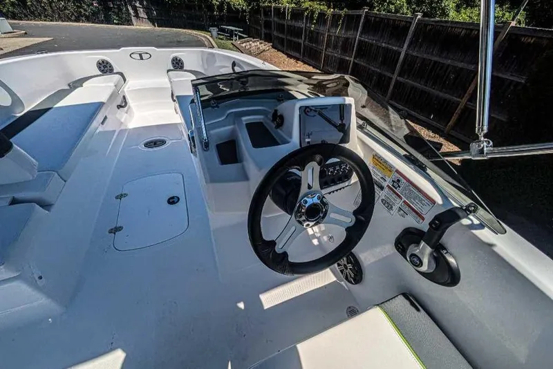 Slide: The Image of 2024 Tahoe T18 boat cockpit with steering wheel and seating area. - 2