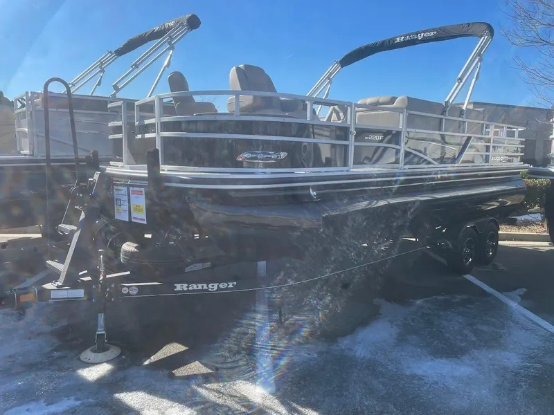 The Image of 2024 Ranger Reata 220F pontoon boat on trailer in outdoor setting. - 0