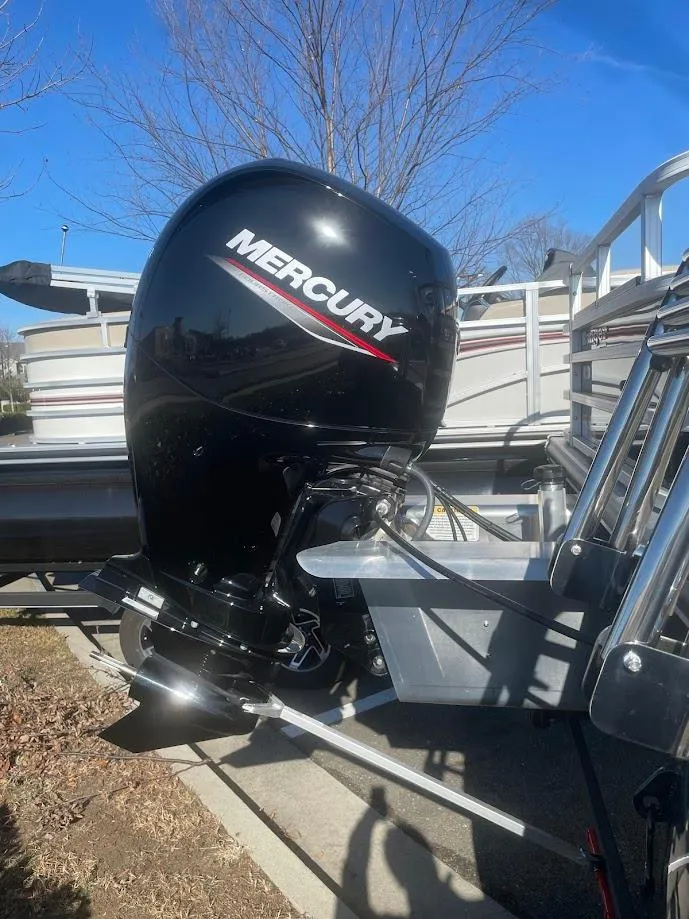 Slide: The Image of 2024 Ranger Reata 220F with Mercury outboard motor, parked outdoors. - 4