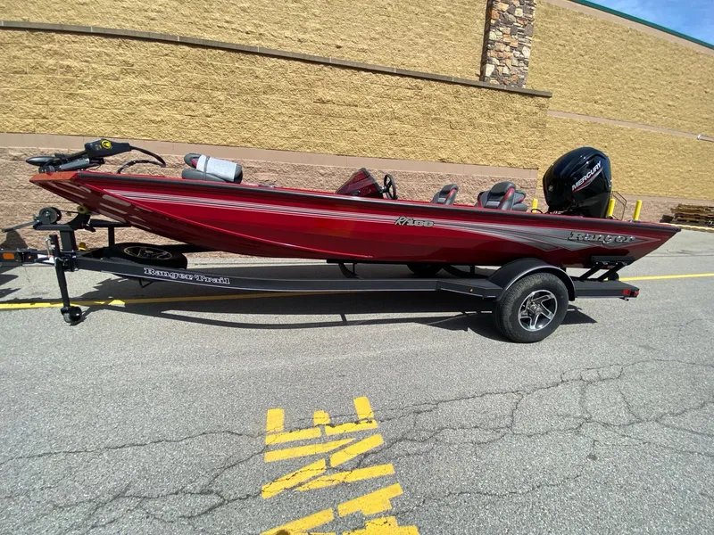The Image of 2024 Ranger RT188 boat in red on a trailer, parked outdoors. - 0