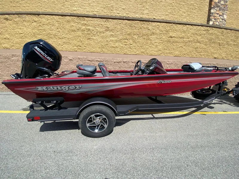 Slide: The Image of 2024 Ranger RT188 boat in red on a trailer, parked outdoors. - 1