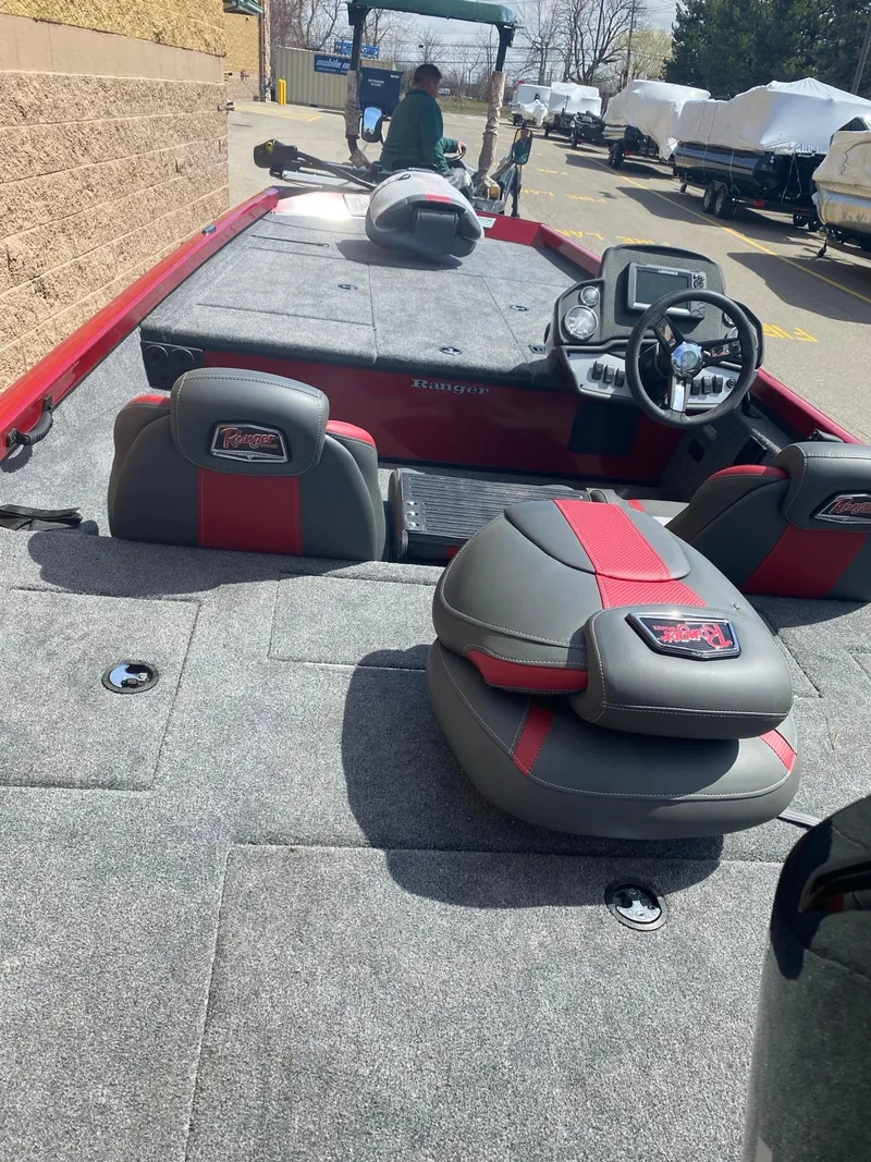 Slide: The Image of 2024 Ranger RT188 boat interior with steering console and seating, parked outdoors. - 4
