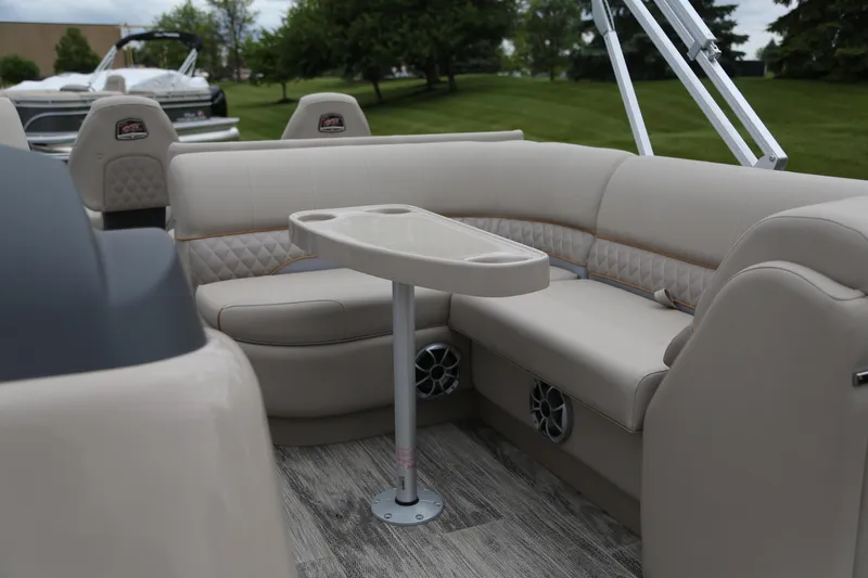 Slide: The Image of 2024 Ranger Reata 220F boat interior with beige seating and table. - 4