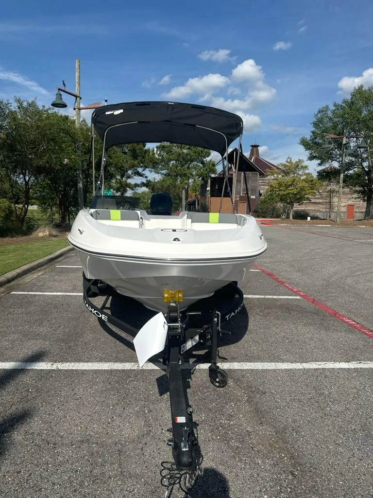 Slide: The Image of 2024 Tahoe T16 boat on trailer in parking lot, under clear blue sky. - 3