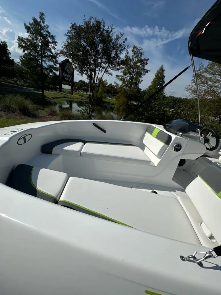Slide: The Image of 2024 Tahoe T16 boat interior with white seating, steering wheel, and scenic background. - 4