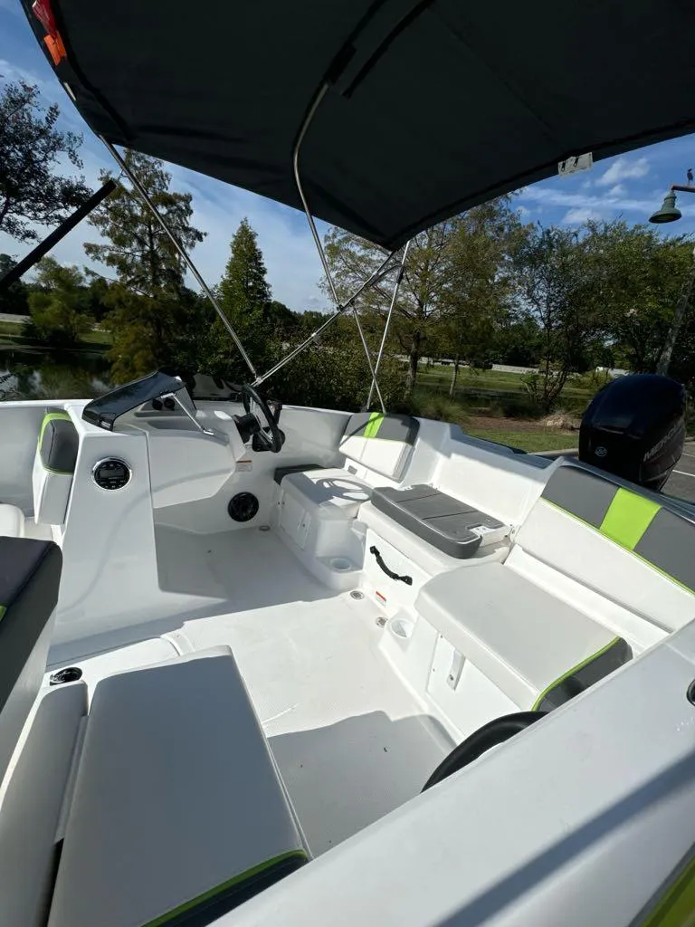 Slide: The Image of 2024 Tahoe T16 boat interior with seating, steering console, and canopy, set against a scenic outdoor backdrop. - 5