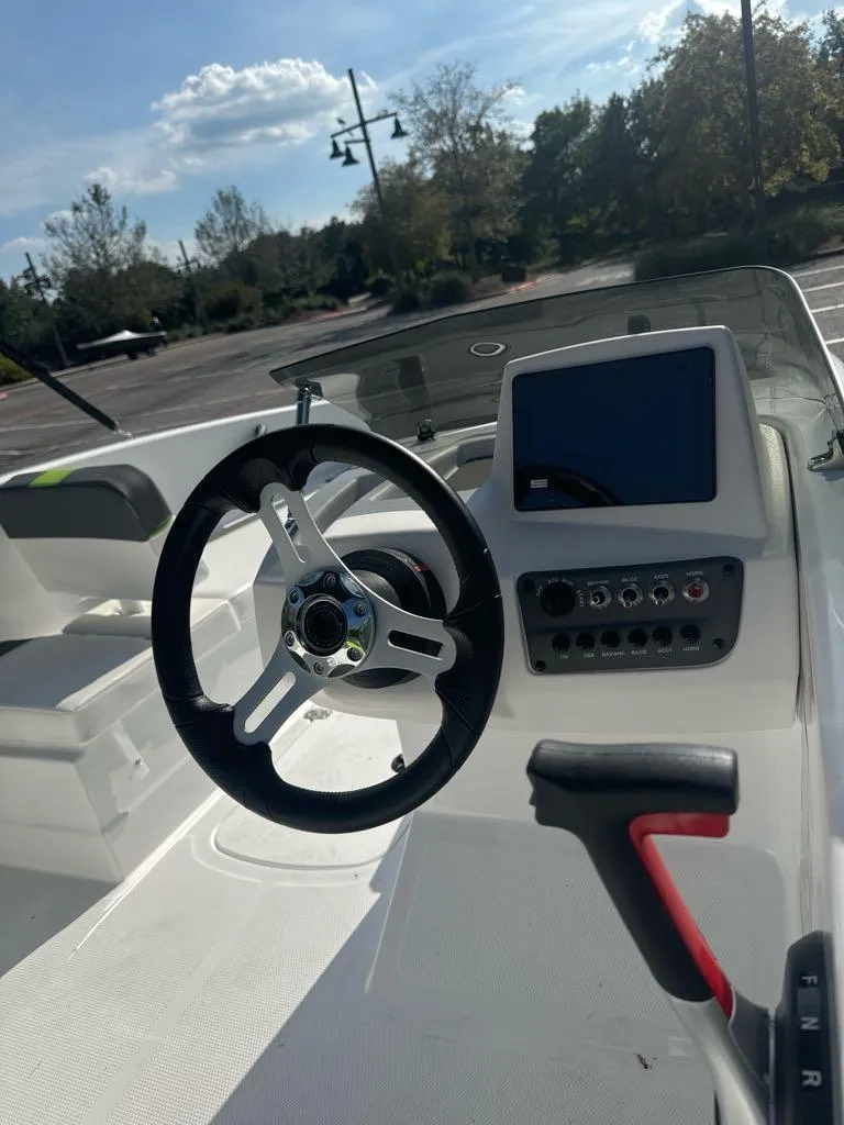 Slide: The Image of 2024 Tahoe T16 boat dashboard with steering wheel and control panel. - 7