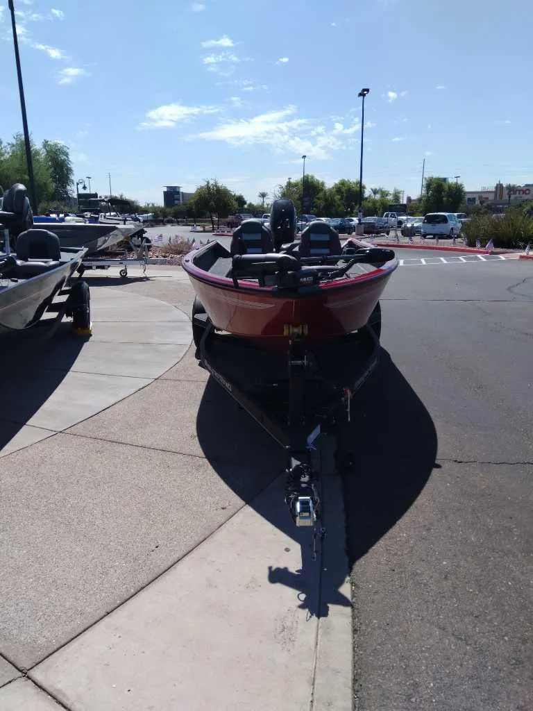 Slide: The Image of 2024 Ranger VS1665T boat parked on a sunny day in a lot. - 2