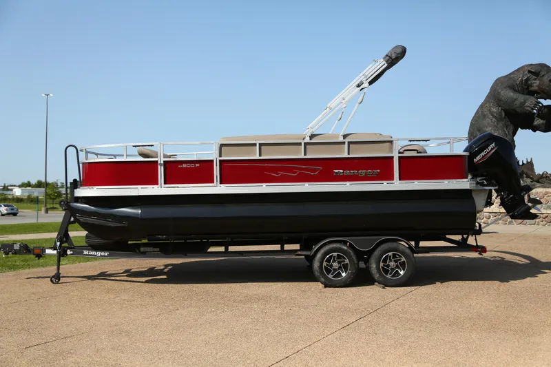 Slide: The Image of 2024 Ranger Reata 200F boat on trailer with bear statues in background. - 1