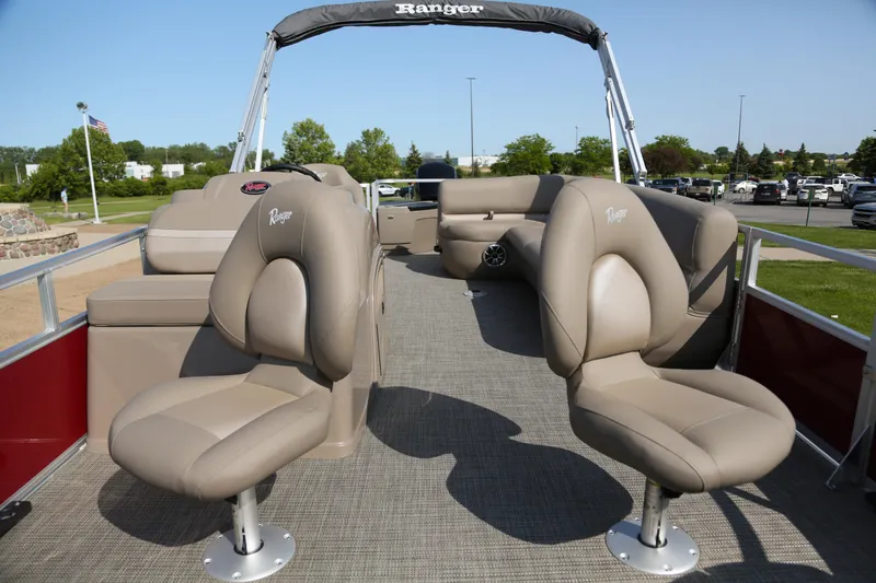 Slide: The Image of 2024 Ranger Reata 200F pontoon boat interior with plush seating and open deck. - 2