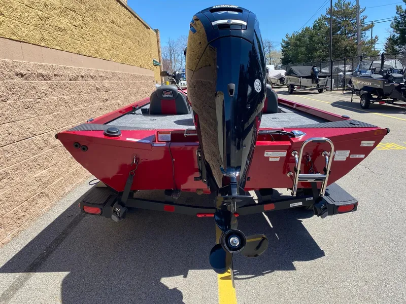 Slide: The Image of 2024 Ranger RT178 boat, red exterior, parked outdoors, rear view with motor and ladder. - 2