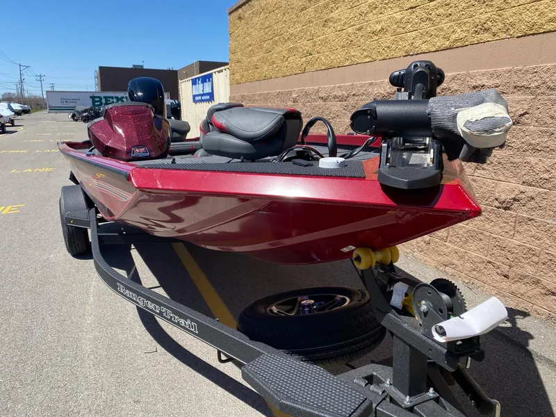 Slide: The Image of 2024 Ranger RT178 boat in red, parked on a trailer in a sunny outdoor setting. - 3
