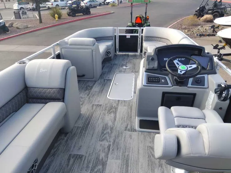 Slide: The Image of 2024 Ranger Reata 223C boat interior with modern seating and steering console. - 2