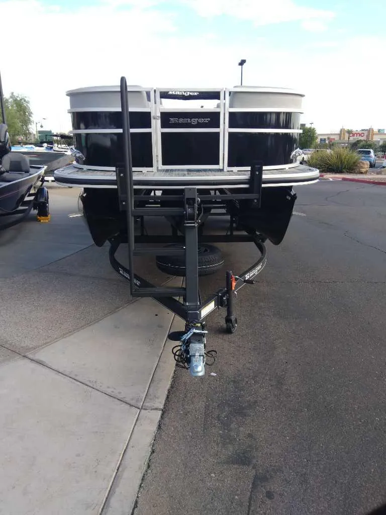 Slide: The Image of 2024 Ranger Reata 223C boat on trailer, parked on pavement. - 4