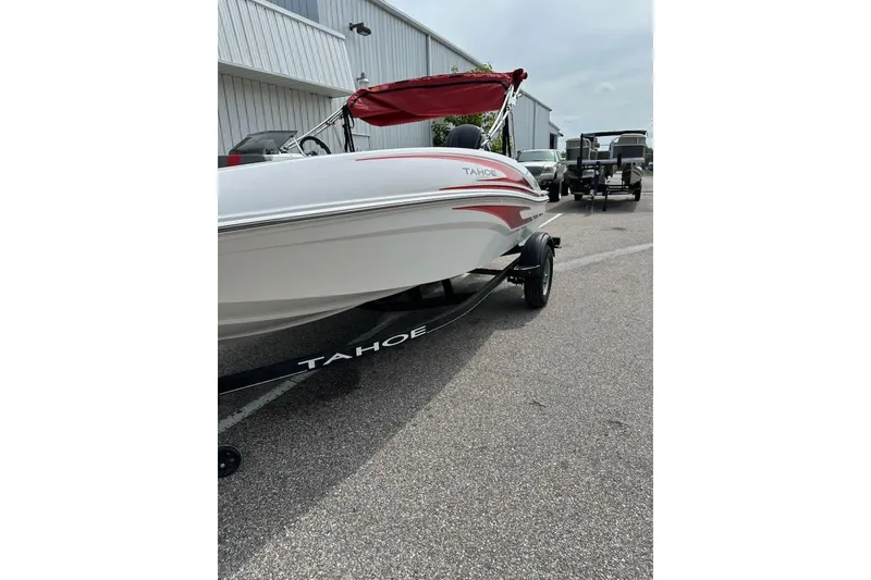 Slide: The Image of 2024 Tahoe T16 boat with red canopy on trailer in parking lot. - 59
