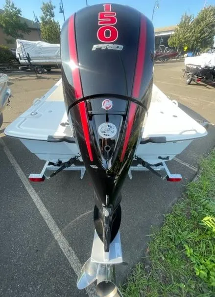 Slide: The Image of 2023 Mako Pro Skiff 19 CC with powerful 150 HP engine in outdoor setting. - 2