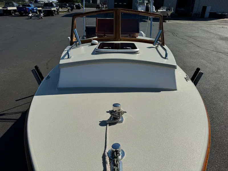 Slide: The Image of 2015 Devlin Pelicano 20 boat, docked, showcasing deck and cabin details. - 12