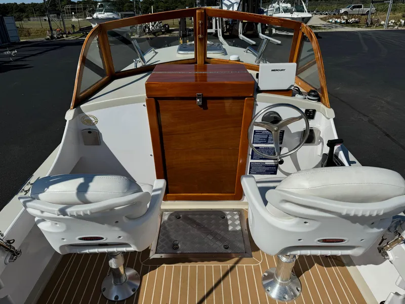 Slide: The Image of Devlin Pelicano 20 boat interior, 2015 model, featuring dual white seats and wooden dashboard. - 15