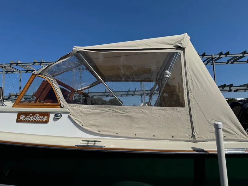 Slide: The Image of Devlin Pelicano 20 boat, 2015 model, with beige canopy and clear windows, named "Adeline." - 6