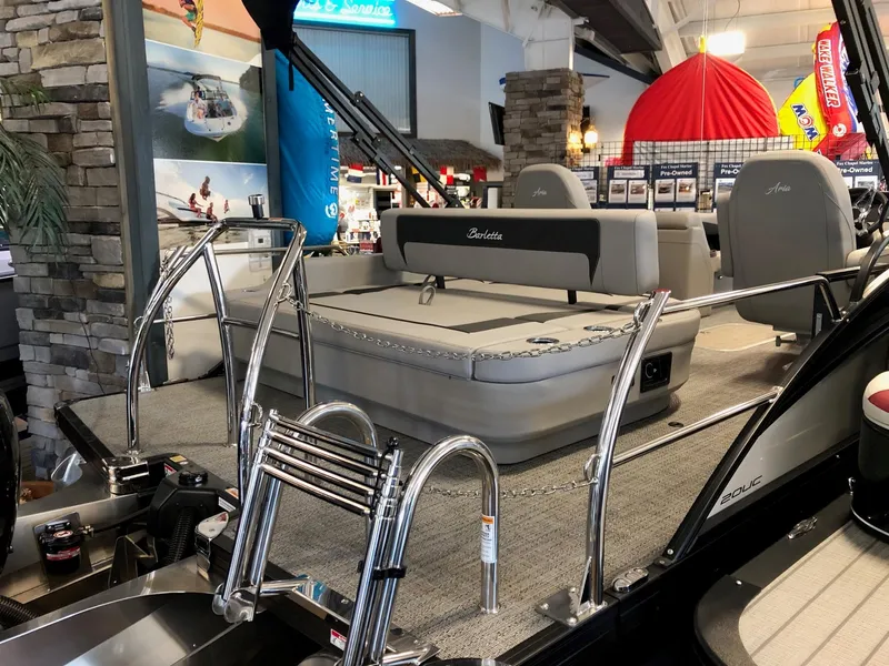 Slide: The Image of 2025 Barletta ARIA 20UC pontoon boat interior with seating and ladder in showroom. - 4