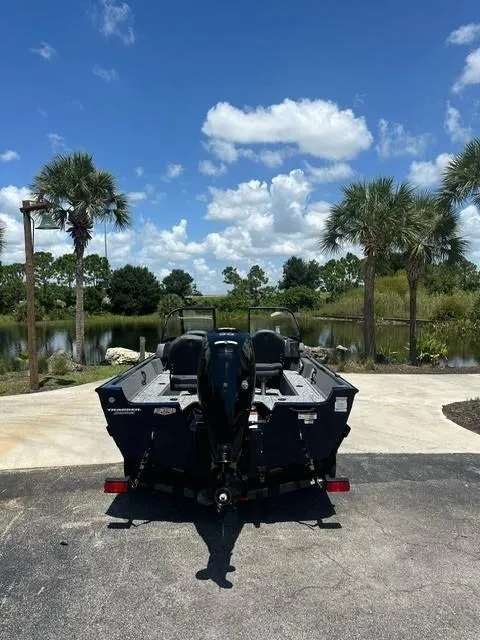 Slide: The Image of 2025 Bass Tracker PGV16WT boat parked near a scenic lake with palm trees. - 4
