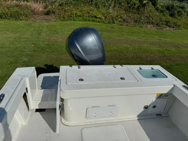 Slide: The Image of 2021 Parker 2320 Sport Cabin boat with outboard motor on grassy area. - 4