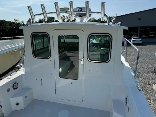 Slide: The Image of 2021 Parker 2320 Sport Cabin boat, rear view, with rod holders and cabin door. - 5