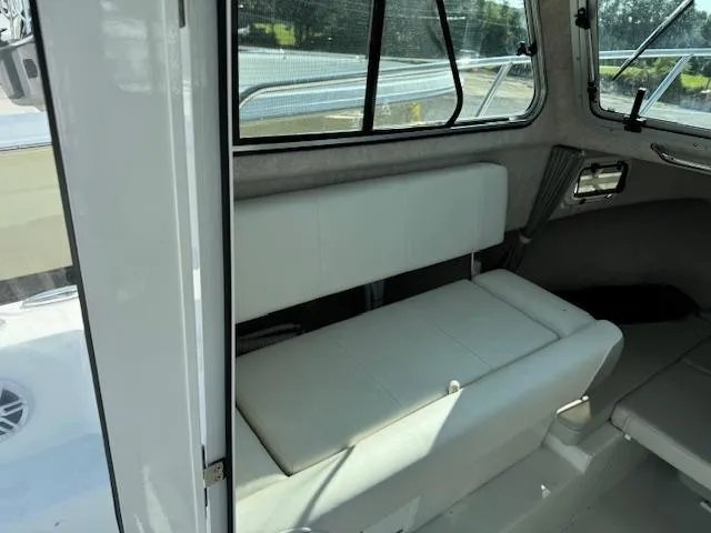 Slide: The Image of 2021 Parker 2320 Sport Cabin interior with white seating and windows. - 6