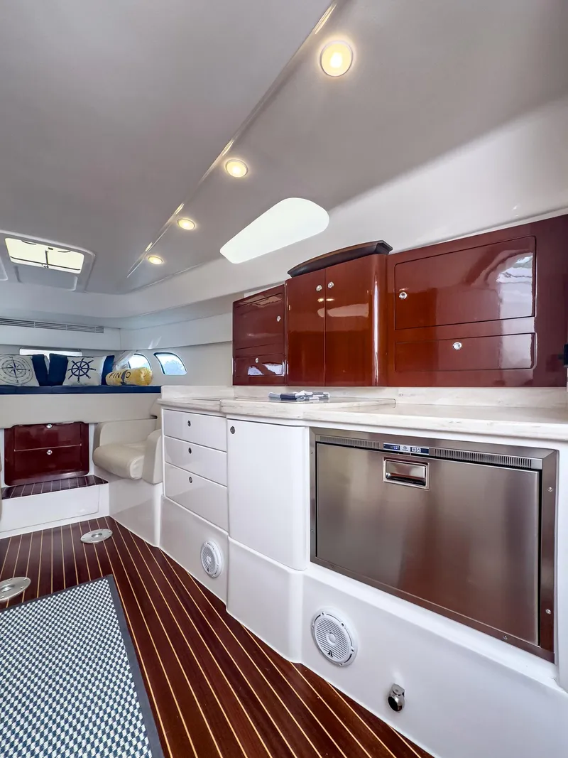 Slide: The Image of Interior of 2017 Intrepid 430 Sport Yacht with modern kitchen and wood flooring. - 13