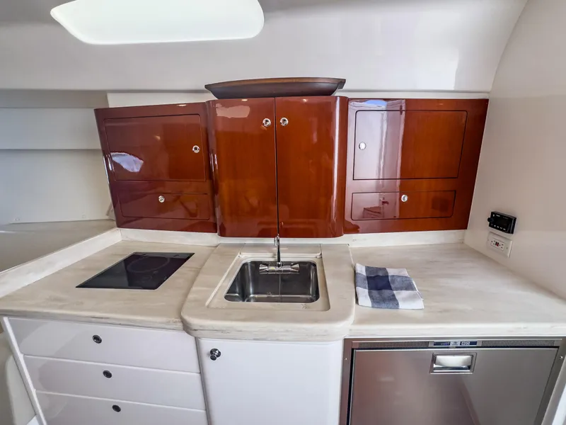 Slide: The Image of 2017 Intrepid 430 Sport Yacht kitchen with wooden cabinets, sink, and modern appliances. - 14