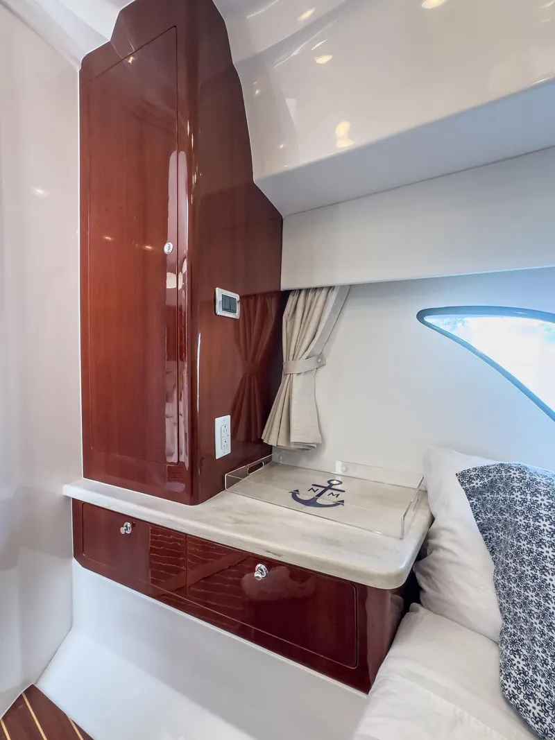 Slide: The Image of 2017 Intrepid 430 Sport Yacht cabin with wooden cabinetry and nautical-themed decor. - 17