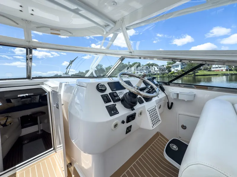 Slide: The Image of 2017 Intrepid 430 Sport Yacht cockpit with modern controls and scenic water view. - 24