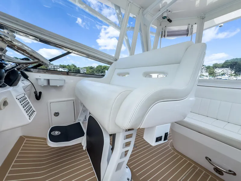 Slide: The Image of 2017 Intrepid 430 Sport Yacht interior with white seating and modern dashboard. - 31