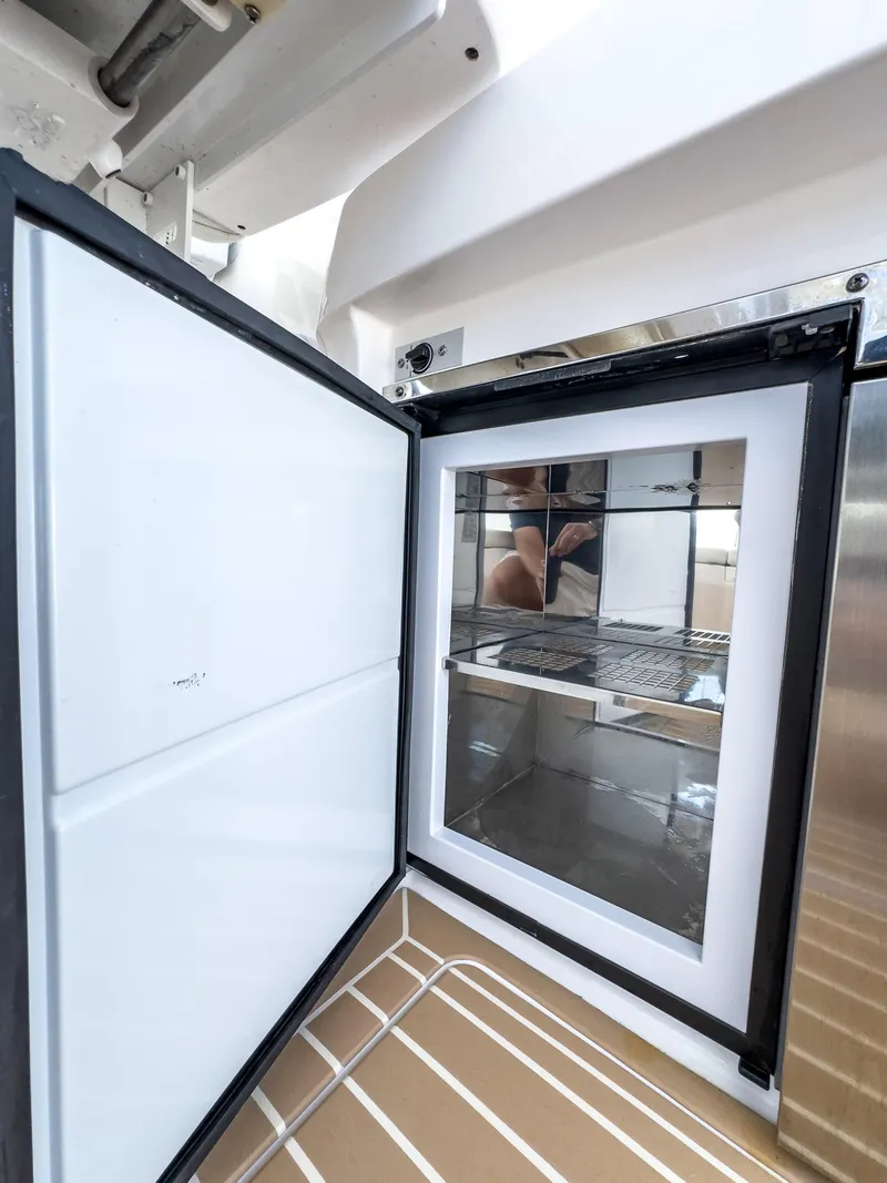 Slide: The Image of Open refrigerator on 2017 Intrepid 430 Sport Yacht, showcasing interior shelving. - 36