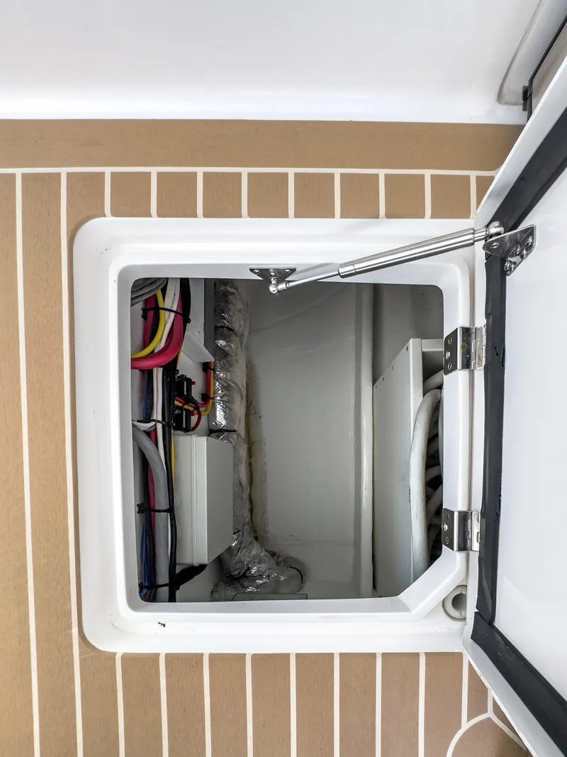 Slide: The Image of 2017 Intrepid 430 Sport Yacht storage compartment with visible wiring and equipment. - 38