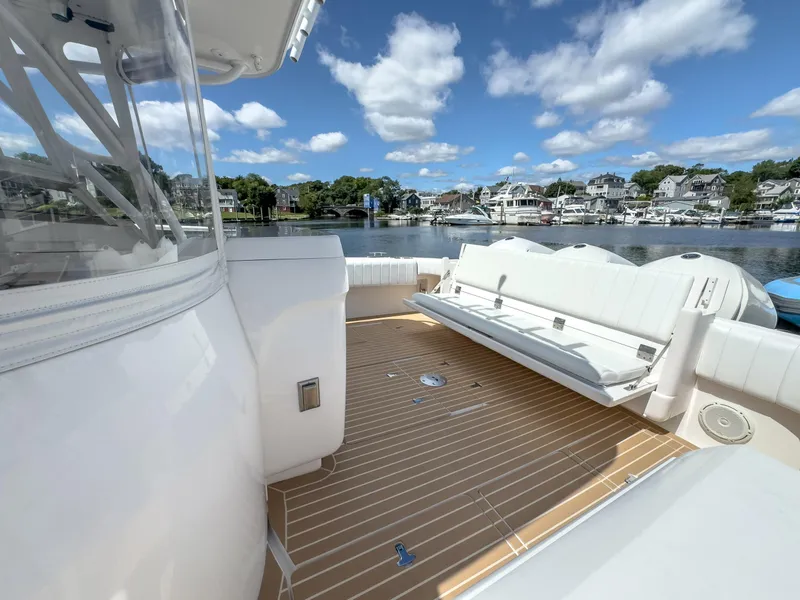 Slide: The Image of 2017 Intrepid 430 Sport Yacht deck with seating, overlooking a serene waterfront. - 40
